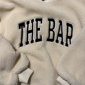 The Bar Cream Sherpa Top with Black Tag